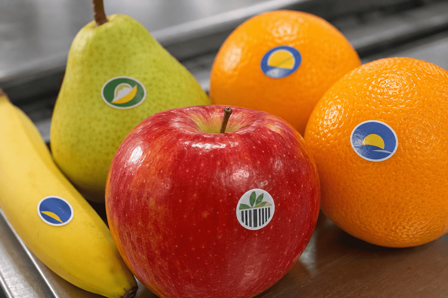 Manzana, naranjas, pera y plátano con pequeñas etiquetas adhesivas para frutas